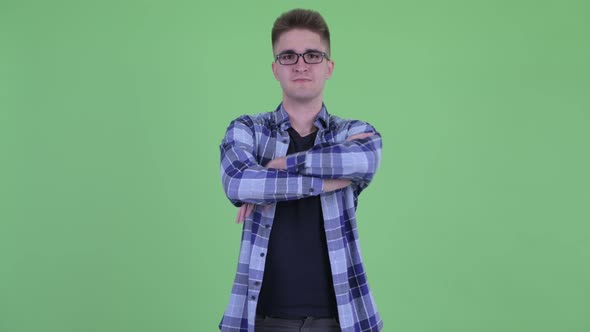 Happy Young Handsome Hipster Man Smiling with Arms Crossed