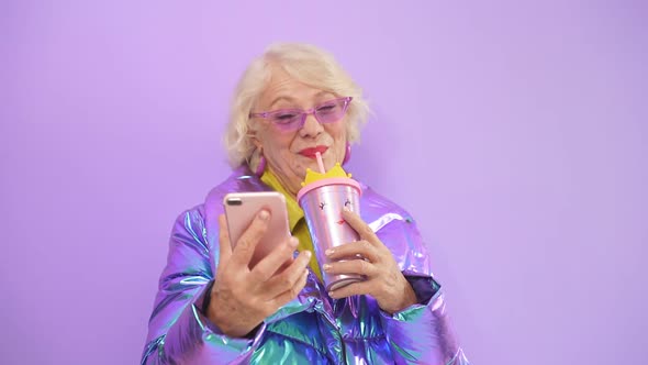 Close-up Portrait of a Modern Woman of Retirement Age Making a Video Call on Her Smartphone on an