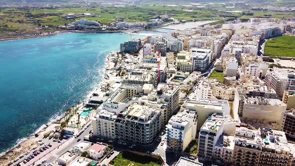 Buildings and coastline of St. Paul Bay in Malta, aerial drone view