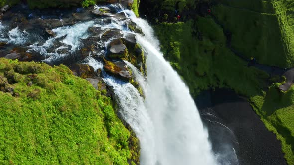 Seljalandsá river falling down as Seljalandsfoss waterfall and creating a Rainbow in Iceland - rotat