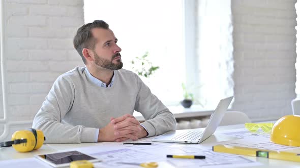 Pensive Young Architect Thinking and Wondering in Office 