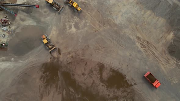 Loaders Tractors and a Dump Truck Drive Off the Gravel Pile at the River Port