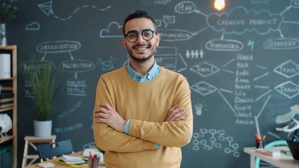 Portrait of Ambitious Arab Man Standing in Office with Arms Crossed Looking at Camera