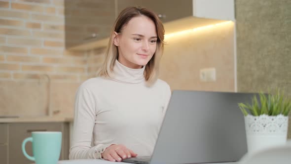 Young Woman Having Video Call To Business Partner Using Laptop at Home. Girl Is Looking at Screen