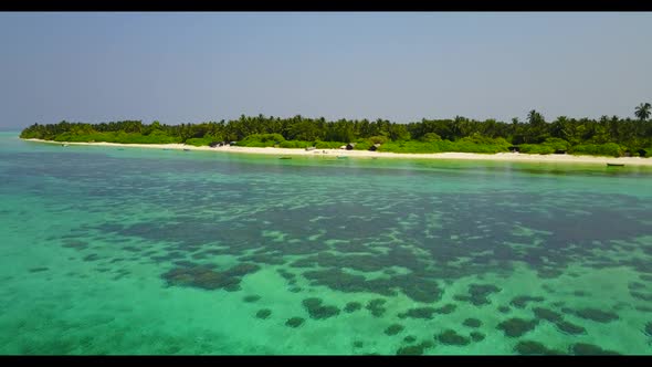 Aerial above seascape of tropical resort beach trip by blue green lagoon with white sandy background