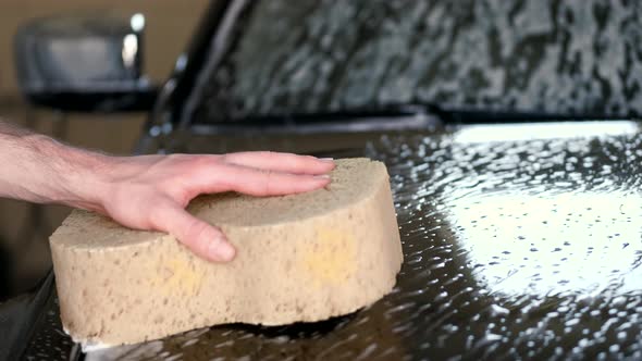 Man Washing His Car in a Garage