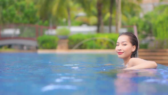 Young asian woman enjoy around outdoor swimming pool for leisure