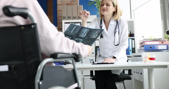 Doctor Discusses Xray of the Spine with Disabled Patient