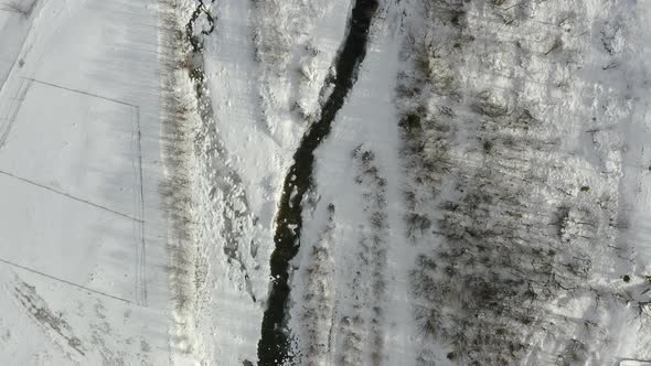 Aerial view of a frozen forest with snow covered trees at winter