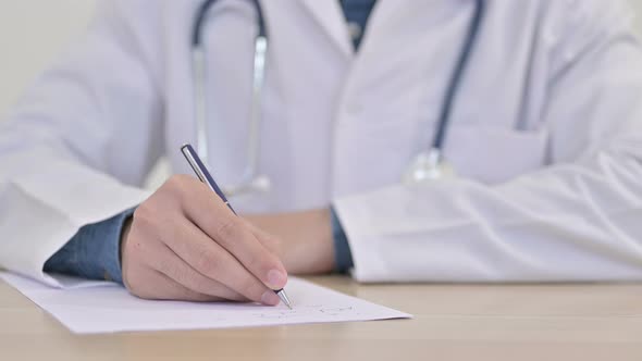 Hands of Doctor Writing on Paper Close Up 