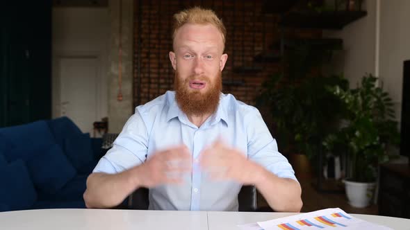 Headshot of Redhead Businessman in Smart Casual Shirt Sis at the Desk