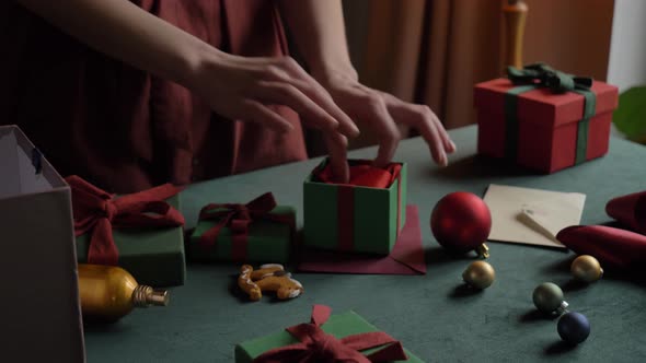 woman preparing gifts for christmas at home on the table