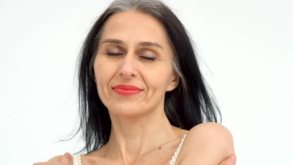 Female Portrait of Middle Aged Woman Starting Getting Greyhaired in Studio with Naked Shoulders on