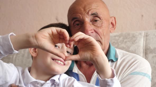 Portrait of a cheerful caucasian boy 6-7 years old and a pensioner 70-79 years old looking at the ca