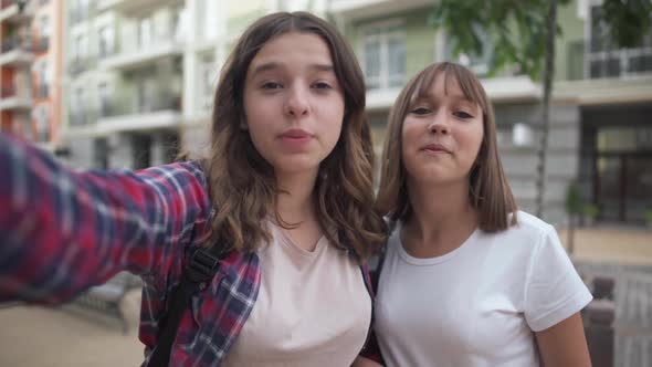 Two Charming Joyful Teenage Bloggers Talking Smiling Standing on City Street