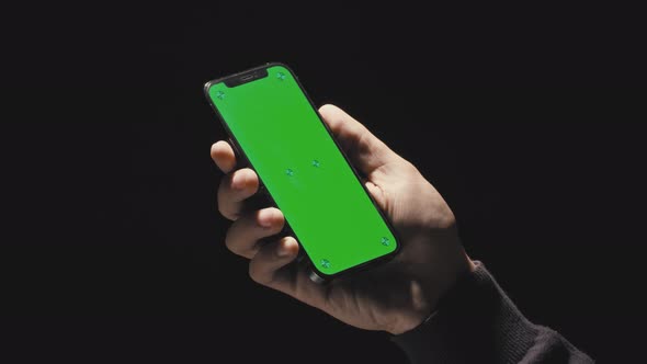 Holding a Green Screen Smartphone with Black Background