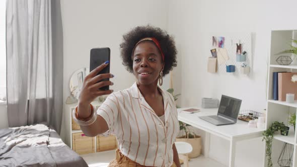 African American Woman Taking Selfie on Smartphone at Home