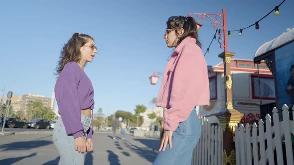 Darkhaired Girls in Colorful Clothes and Sunglasses Stand and Talk