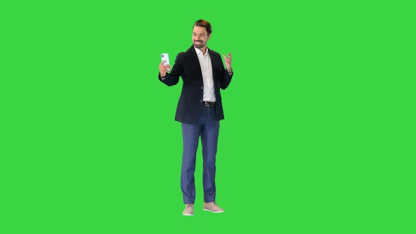 Attractive Business Man Is Making a Selfie on a Green Screen Chroma Key