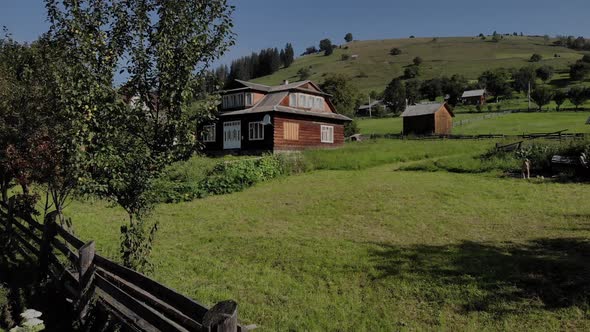 Wooden House on Green Meadow in Carpathian Mountains