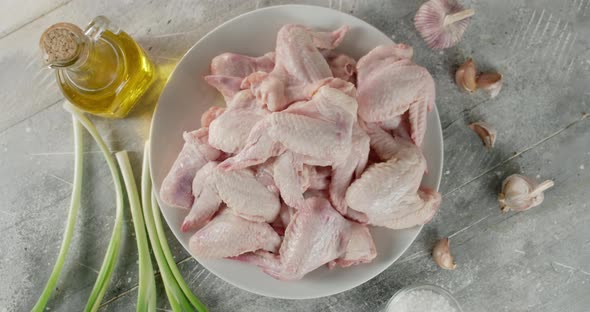 Raw Chicken Pieces of Wings with Garlic and Onion Rotate.