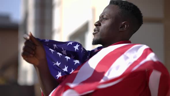 Side View Proud Confident African American Man Wrapping in USA Flag Standing in Sunshine on Backyard