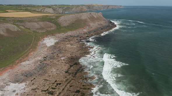 Aerial Drone View of Waves Breaking Against a Rocky Ocean Coastline