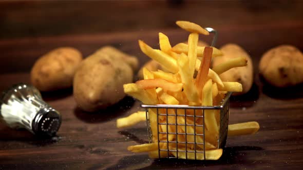 Super Slow Motion Basket with French Fries Falls on the Table