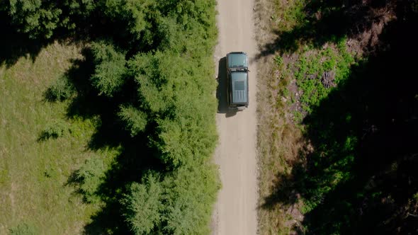 Aerial Drone View, Top Down Flying Over Forest Road with Car Driving Along Forest Road in Mountain