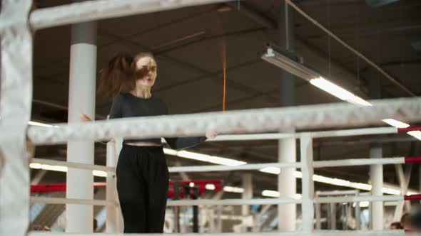 Young Attractive Woman in Sport Clothes Jumping Over the Rope on Boxing Ring