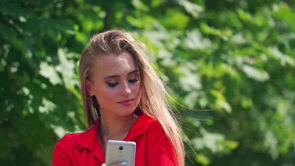 Smiling woman using mobile phone. Beautiful stylish woman holding mobile phone