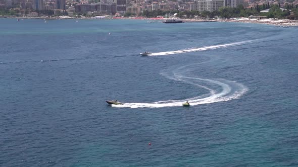 Motor Boat Carries an Inflatable Pill with Tourists Across the Bay