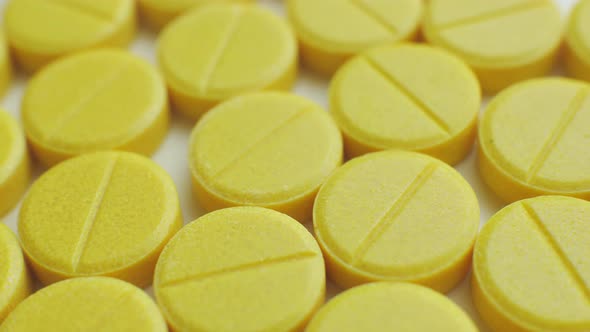 Closeup of Many Yellow Pills Spinning on a Turntable