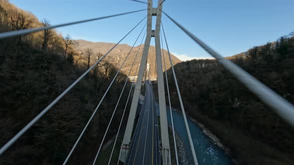 Aerial View White Car Automobile Riding on Cable Stayed Bridge Mountain River and Autumn Wood Trees