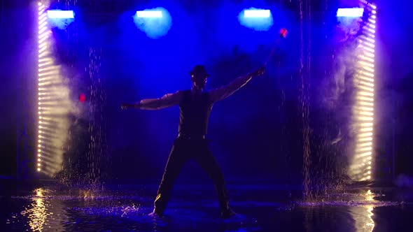 A Man Is Silhouetted with Glowing Red Grenade in a Dark Smoky Studio. A Stylish Entertainer Performs