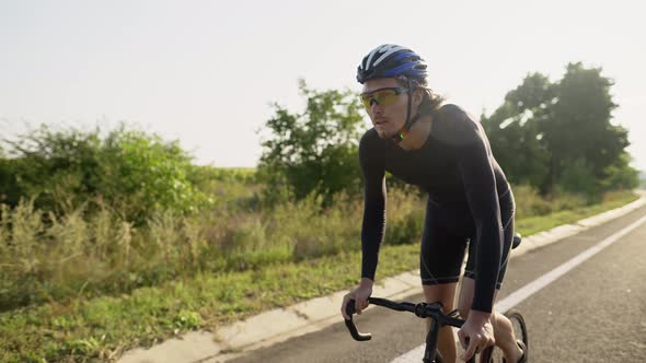 Professional Cycling Athlete Riding Racing Bicycle Training for Competition Race on Open Road