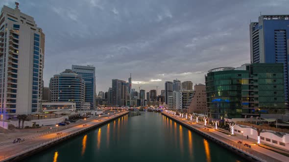 View of Dubai Marina Towers and Canal in Dubai Night to Day Timelapse