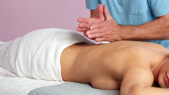 Male physiotherapist giving back massage to female patient