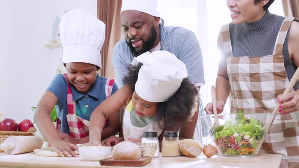 Happy African American family enjoying cooking food. Family in kitchen