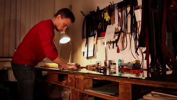 Personal Workshop  Man Polishes a Piece of Leather with Wax