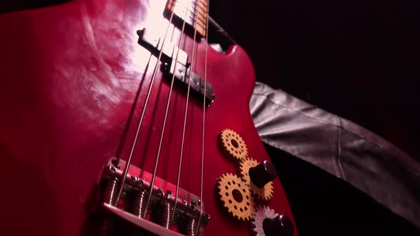 Detailed Macro Shot of Male Hands Playing Red Bass Guitar