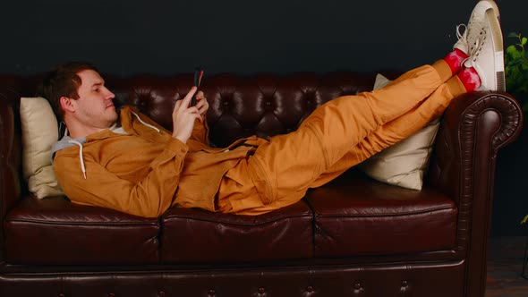 Man Browsing Smartphone on Couch