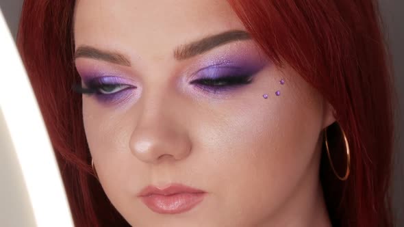 Closeup View of Beautiful Young Girl Model with Bright Red Hair and Purple Makeup Posing in the