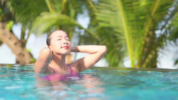 Young asian woman enjoy around outdoor swimming pool for leisure