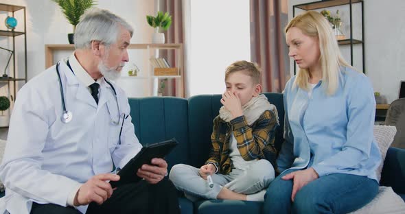 Woman Sitting Near Her Sick Tired Son which Talking with Respected Attantive Doctor
