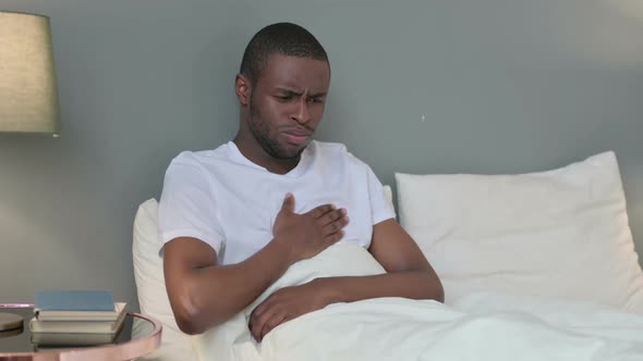Sick Young African Man Coughing in Bed