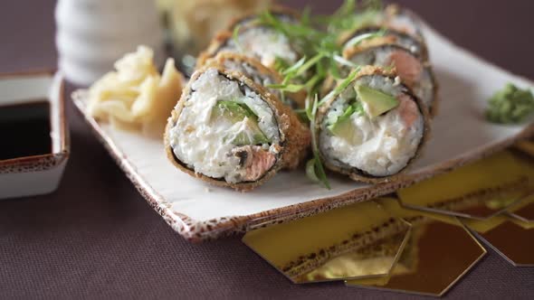 The camera moves away from the sushi set beautifully decorated on a plate