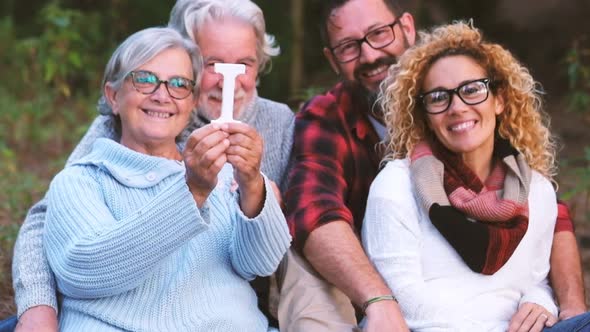 Group of mixed ages generations people smiling and showing blocks letters with  life word