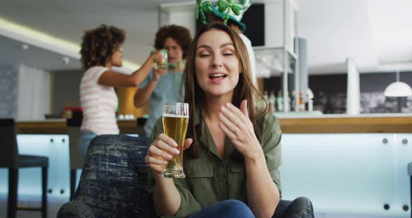 Diverse group of happy friends celebrating st patrick's day drinking beers at a bar