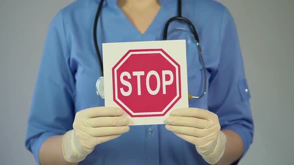 Stop Sign in Female Physician Hands, Doctor Warning About Diseases, Health Care